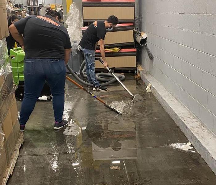 SERVPRO workers removing water from area to begin drying process 