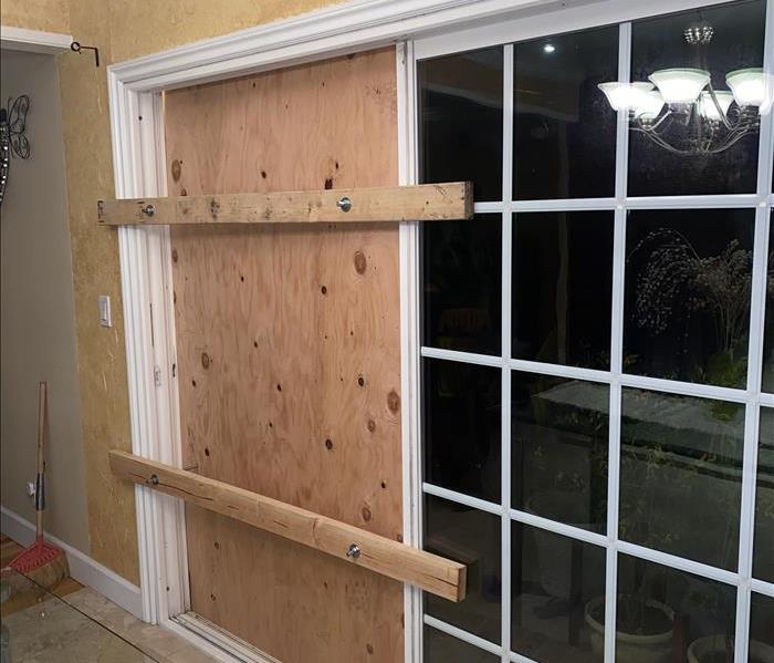 Plywood used to board up broken sliding door 