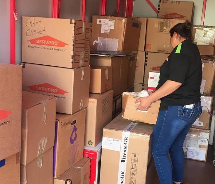 Woman stacking cardboard boxes inside a storage container