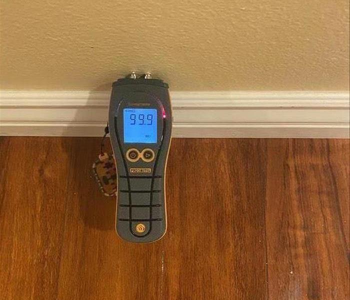 Moisture meter being used on a wall 