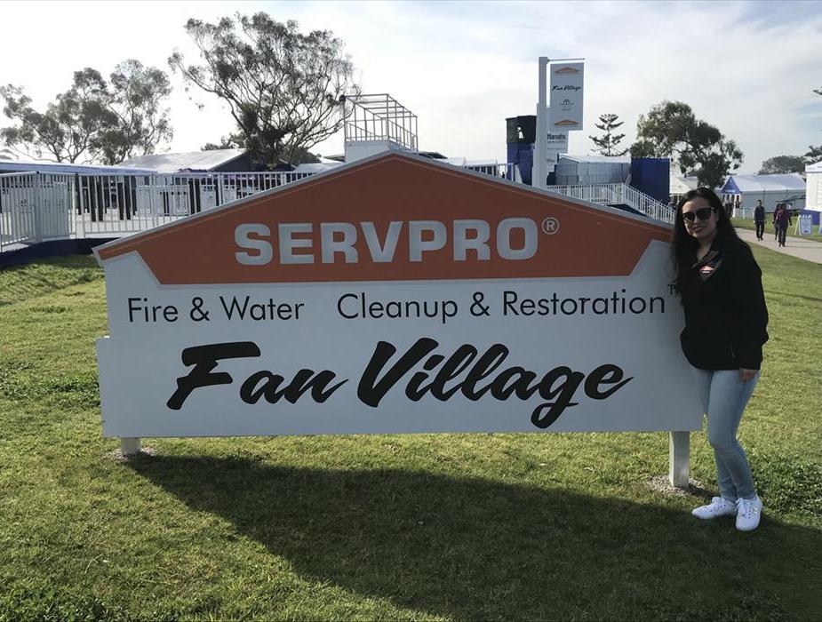 Adriana Castro standing in front of the SERVPRO Fan Village sign 
